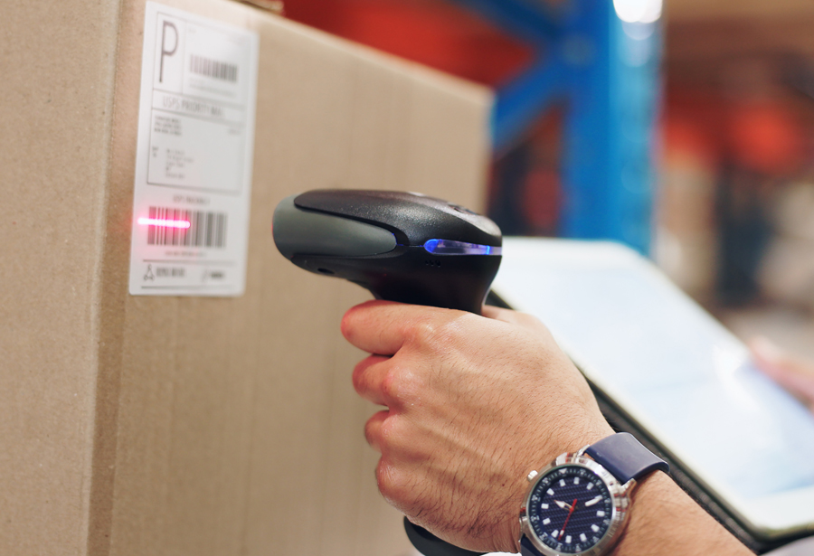 Operatore utilizza lettore barcode per la verifica di etichette e spedizioni logistiche