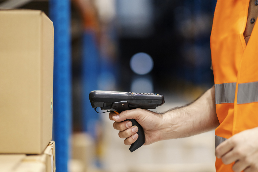 Operatore utilizza lettore barcode per la scansione di pacchi in magazzino